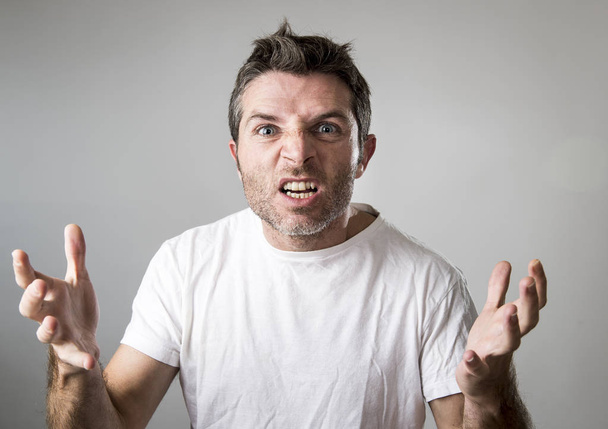 young attractive man with blue eyes looking angry and mad in rage emotion and upset - Photo, Image