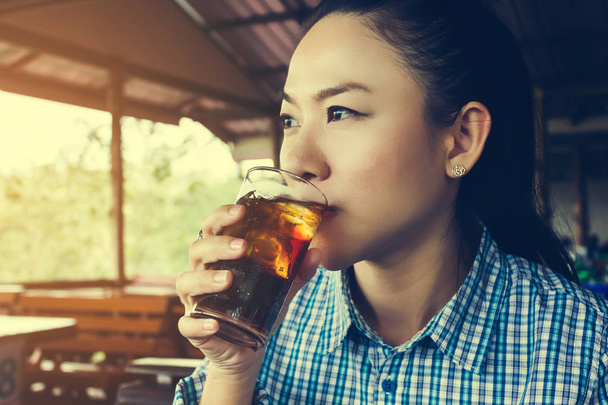 Aziatische vrouwen drinken cola in zonnige dag in restaurant, glas frisdrank - Foto, afbeelding
