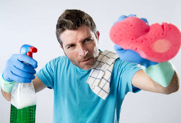 чоловік зосередився на прибиранні будинку з пляшкою розпилювача і губкою для миття скла
 - Фото, зображення