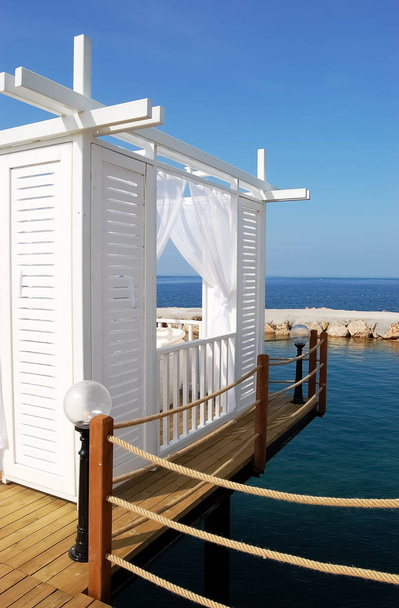 Белая пляжная палатка на фоне синего моря в отеле
. - Фото, изображение