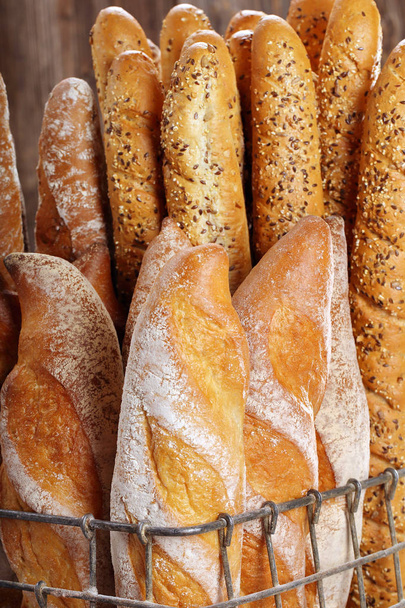 Fresh baguettes in metal basket in bakery - Photo, Image