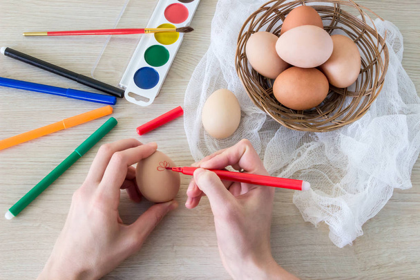 a mão da mulher pinta o marcador de comida de ovo de galinha da Páscoa
 - Foto, Imagem