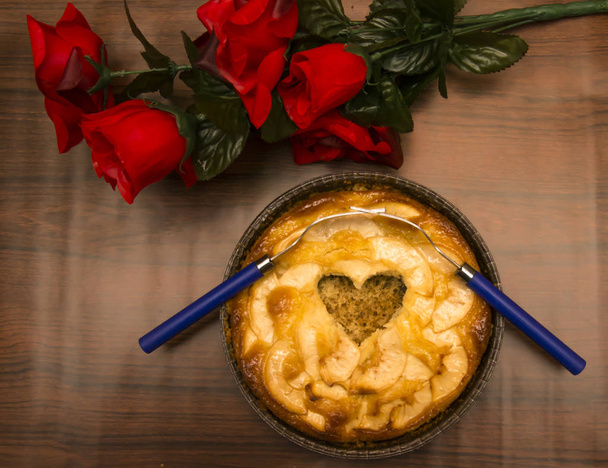 Apple pie with a hollow in the shape of a heart and two forks in - Photo, Image
