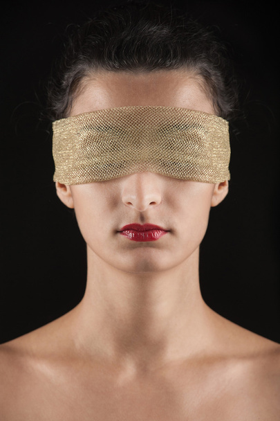 Close up of woman constrained by golden ring on eyes. Conceptual - 写真・画像