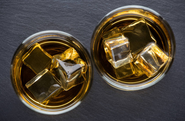 Twee ronde bril leeftijd whiskey met ijs - Foto, afbeelding
