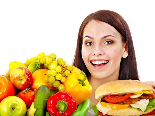 vrouw kiezen tussen fruit en hamburger. - Foto, afbeelding