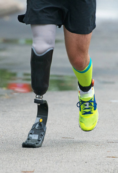 Чоловік біжить з протезною ногою на вулиці
. - Фото, зображення