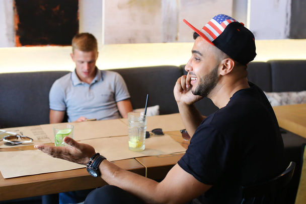 Amigos varones en la charla café discutir con la tecnología tableta del teléfono
 - Foto, imagen