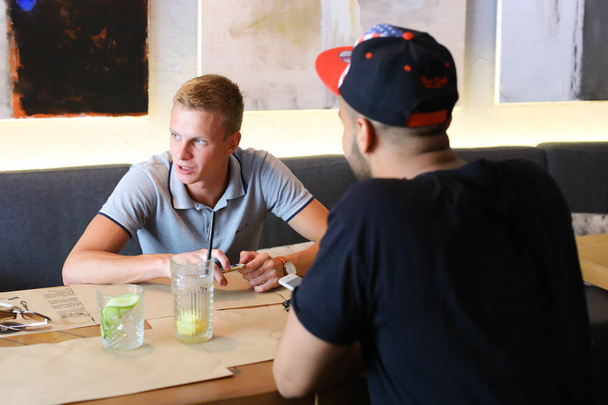 Amigos varones en la charla café discutir con la tecnología tableta del teléfono
 - Foto, Imagen