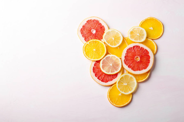 Citrus fruit Heart from slices of lemon, orange, grapefruit on white background. Love, healthy, ecology concept. - 写真・画像