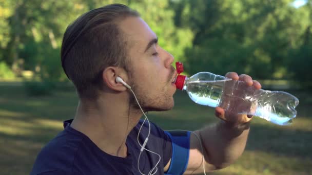 Un hombre bebe agua después del entrenamiento en el bosque.
. - Metraje, vídeo