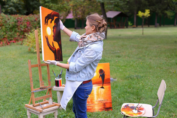 Művész nő tart festés és ránéz, pózol a kamera egy - Fotó, kép