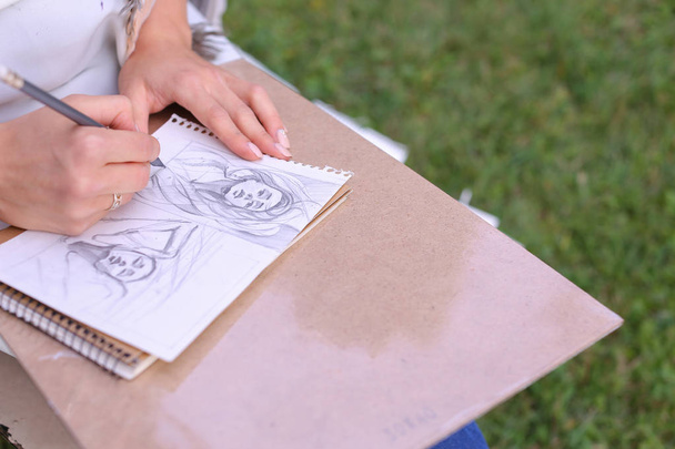 mano de artista chica hace seguro agudo lápiz trazos en álbum Pag
 - Foto, imagen