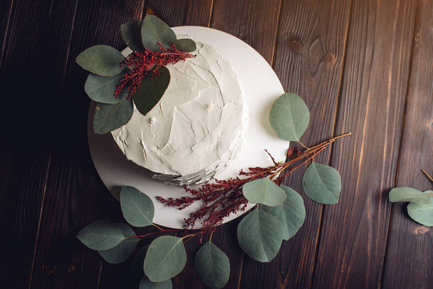 bolo de creme branco decorado com folhas verdes
 - Foto, Imagem