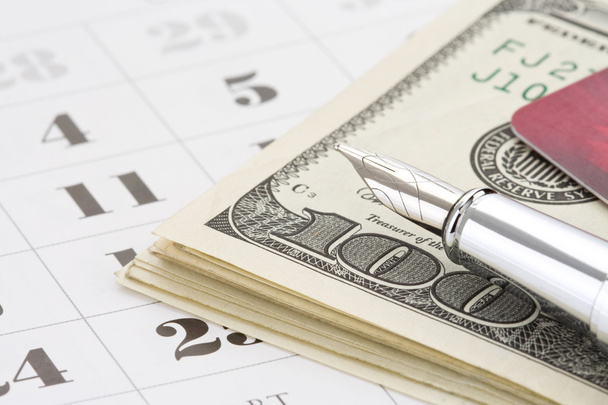 ink pen and dollar money on calendar - Фото, зображення