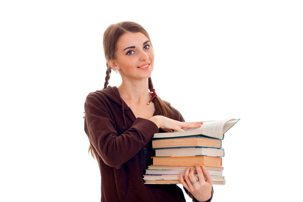 cheerful young student girl with books in brown sport clothes looking at the camera and smiling isolated on white background. student years concept. study concept. - Foto, immagini