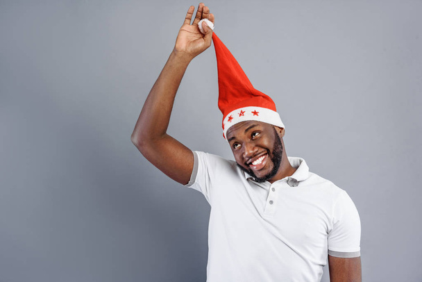 Happy guy playing with Christmas cap - Zdjęcie, obraz