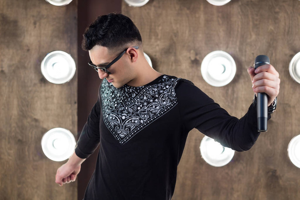 Cantante pop masculino realiza en escena en proyectores luces
 - Foto, imagen