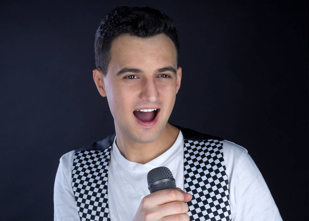 Jeune chanteur pop mâle aux cheveux noirs chante au microphone
 - Photo, image