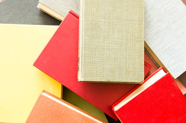 μια στοίβα από πολύχρωμα βιβλία σε μια βιβλιοθήκη - Φωτογραφία, εικόνα
