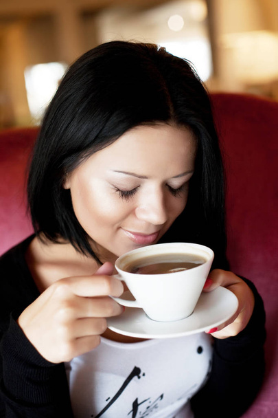 young woman sitting in a cafe drinking coffee - Foto, Imagem