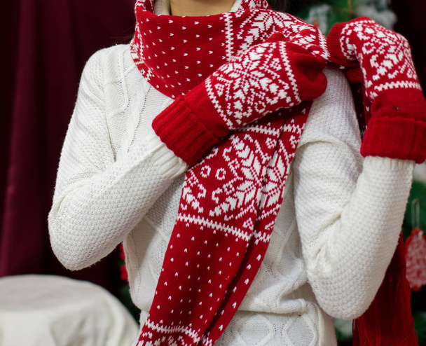 Ένα κορίτσι με λευκό πουλόβερ και ένα κόκκινο κασκόλ. - Φωτογραφία, εικόνα