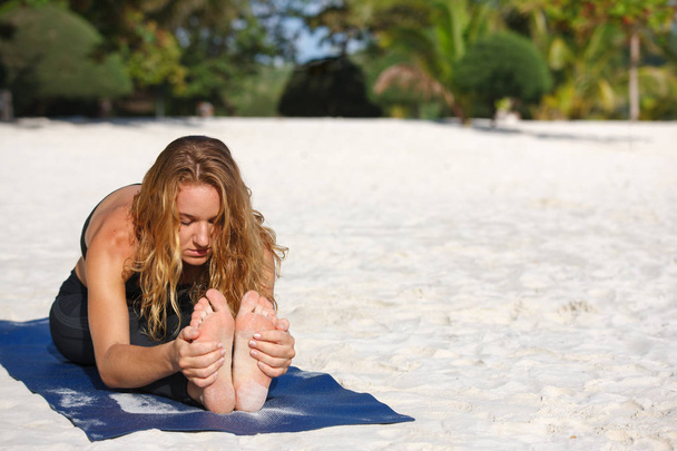 Young woman practicing yoga on the beach - Foto, Imagem