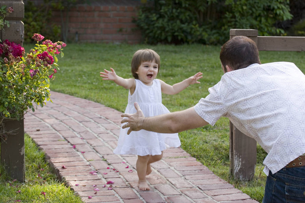 Portrait of a happy little girl running to her father. - Foto, Bild