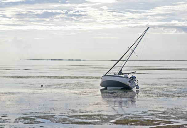 Veleiro encalhado na maré baixa
 - Foto, Imagem