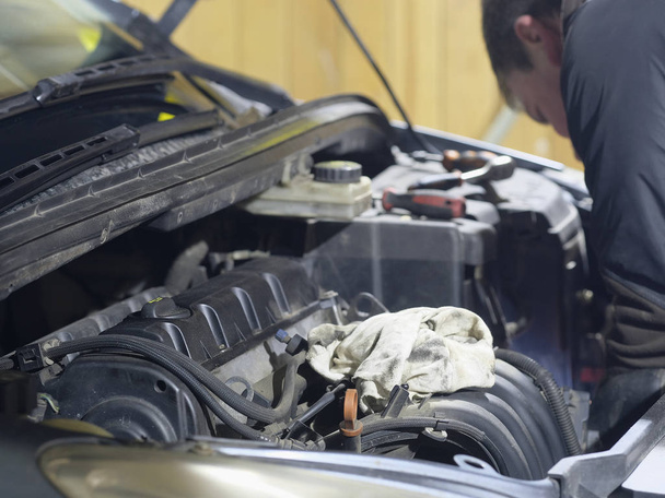 Mechanic repairs car in a car repair station - Фото, зображення