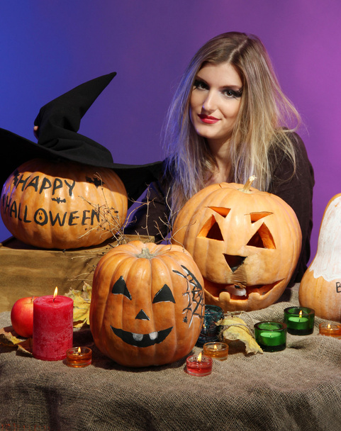Halloween witch with pumpkins on color background - Foto, Bild