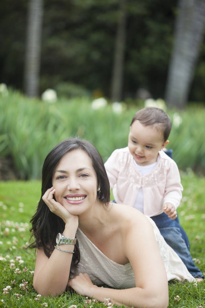 Malá holčička hraje s mámou na trávě - Fotografie, Obrázek