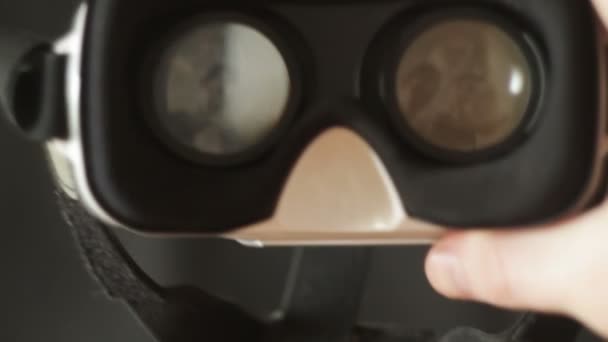 Mans hands take virtual reality glasses, vr and wear them, black background - Felvétel, videó