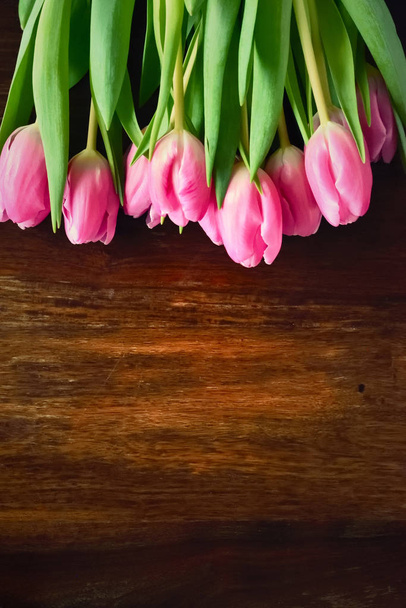 Bouquet de fleurs de tulipes roses sur une table en bois
 - Photo, image