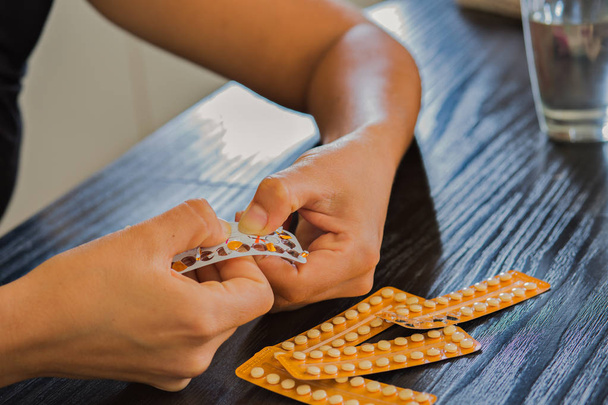 Mujer manos abriendo píldoras anticonceptivas
. - Foto, imagen