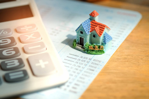 Modelo da casa com calculadora no banco do livro
. - Foto, Imagem