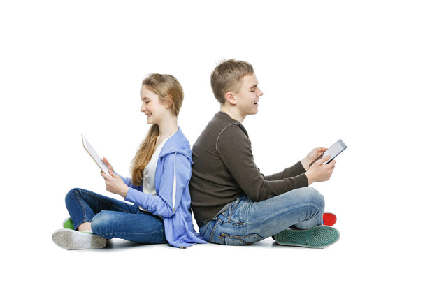 Teen boy and girl sitting with tablets - Photo, Image