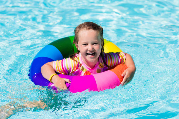 Little girl with toy ring in swimming pool - Photo, Image