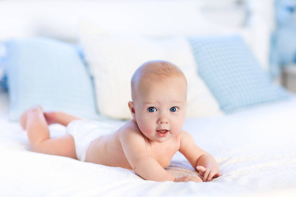 Baby in diaper in bed. Newborn at home. - Foto, Bild