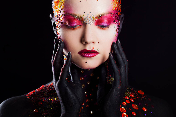 Young attractive girl in bright art-makeup, body painting. Touching face. Eyes closed - Фото, зображення