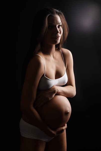 Mujer joven embarazada en ropa interior en el estudio
 - Foto, imagen