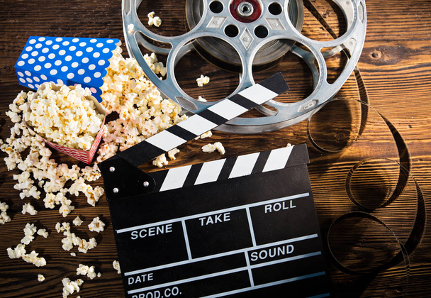 Cinema concept of vintage film reel with popcorn. - Фото, изображение