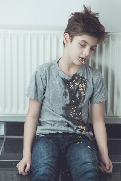 Young boy slumped against a radiator - Photo, Image