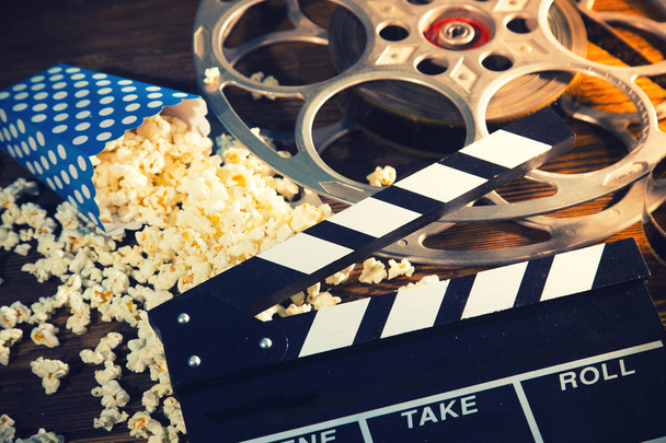 Cinema concept of vintage film reel with popcorn. - Photo, image