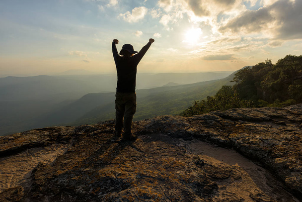Hombre con los brazos levantados en la cima de una roca reunión sol - concepto de éxito
 - Foto, Imagen