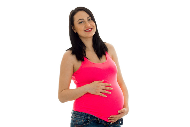 happy pregnant future mother in pink shirt posing isolated on white background - Foto, immagini