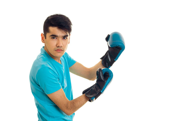 portrait of strong guy practicing boxing in blue gloves isolated on white background - Foto, Bild