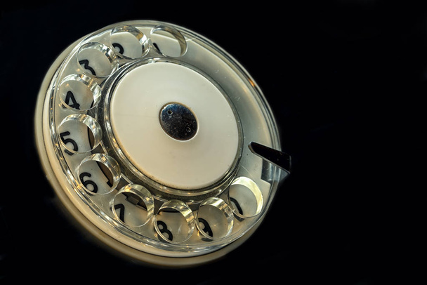 antique retro telephone circle with numbers, on the black background, angle view with copy space - Фото, зображення
