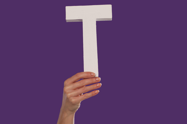Female hand holding up the letter T from the bottom - Photo, Image
