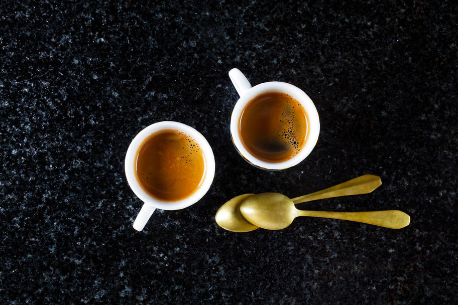 two cups of fresh Coffee Espresso on black Marble and two golden - Фото, изображение